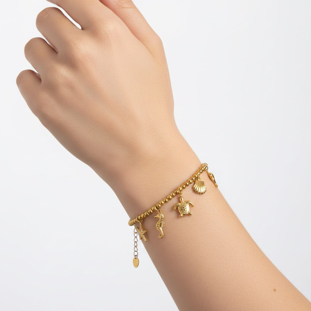 Bracelet en acier avec sphères de 6 mm et breloques hochet marines